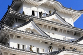 姫路城大天守の屋根に乗って清掃するレンジャー隊員＝姫路市本町