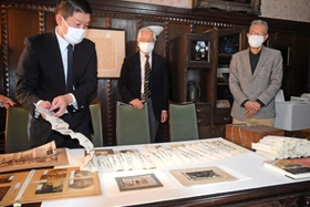 広岡家文書の一部を解説する神戸大経済経営研究所の高槻泰郎准教授（左）＝神戸市灘区六甲台町、神戸大兼松記念館