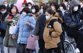 寒風に身を縮めて行き交う通勤客ら＝２３日午前、神戸市中央区元町通１