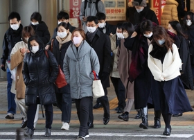 冷たい風に身を縮める人たち＝２３日午前、神戸市中央区三宮町１