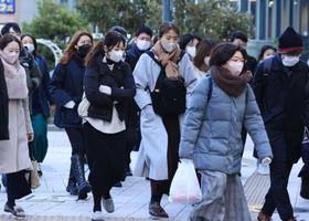 冷たい風に身を縮める人たち＝２３日午前、神戸市中央区加納町６