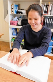 点字教科書で勉強する浅井花音さん＝神戸市立盲学校