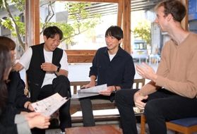 ゲストたちと談笑する朴徹雄さん（右から２人目）＝神戸市灘区城内通４、ゲストハウス「萬家」