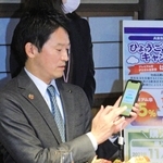 スマートフォンを手に「はばタンＰａｙ（ペイ）」の使い方を説明する斎藤元彦知事＝神戸市東灘区御影塚町１、神戸酒心館