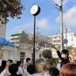 校門横で時を刻む「アッコちゃんの時計」＝神戸市灘区船寺通３、西灘小学校
