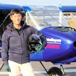 新明和工業の宮内空野さん。自身も携わったヤマハ発動機との共同開発機の前で＝静岡県静岡市清水区、富士川滑空場