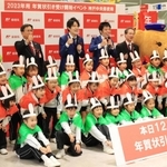 年賀状の引き受け開始をＰＲする熊内幼稚園の園児と桂きん太郎さん（後列左）、お笑いコンビ「スマイル」の２人（同中央）＝１５日午前、神戸市中央区栄町通６、神戸中央郵便局（撮影・吉田敦史）