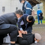 不審者役を取り押さえる警察官＝１６日午後、智頭急行苔縄駅