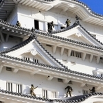 姫路城大天守の屋根に乗って清掃するレンジャー隊員＝姫路市本町