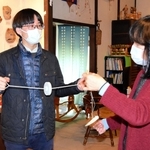 日本玩具博物館でぶんぶんごまを体験しながら、尾崎織女学芸員（右）の説明を聞く長尾亮虎さん＝姫路市香寺町中仁野