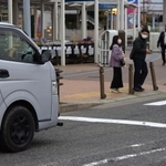 信号機のない横断歩道で、歩行者を前に一時停止した車＝神戸市内