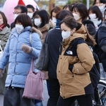 寒風に身を縮めて行き交う通勤客ら＝２３日午前、神戸市中央区元町通１