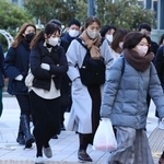 冷たい風に身を縮める人たち＝２３日午前、神戸市中央区加納町６