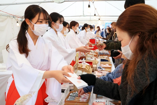 参拝客に縁起物を手渡す巫女（みこ）＝１日午後、神戸市中央区下山手通１、生田神社