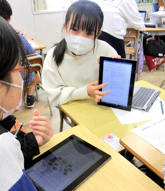 パソコンの画面を見せ合い、震災について調べたことを発表する５年生＝西灘小学校