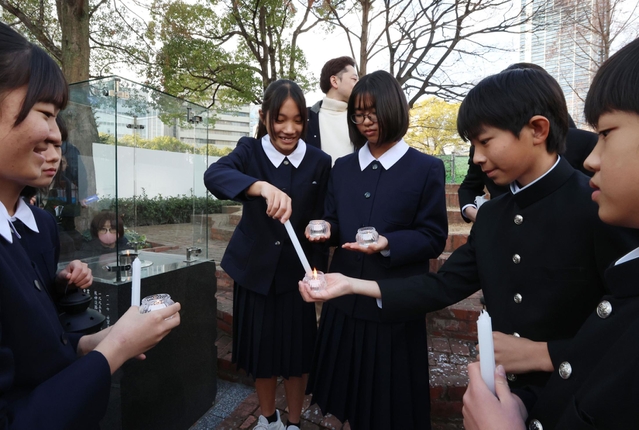 「１．１７希望の灯り」から火を移す参加者ら＝８日午後、神戸市中央区加納町６