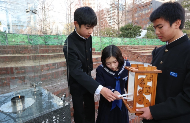 「１．１７希望の灯り」から火を移す参加者ら＝８日午後、神戸市中央区加納町６