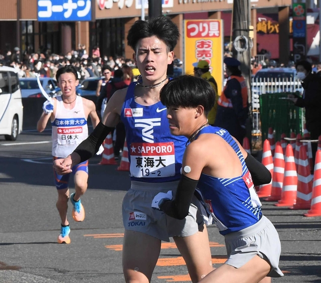 ２区、たすきを渡す東海大・石原翔太郎（中央）。後ろは日体大の藤本珠輝＝戸塚中継所