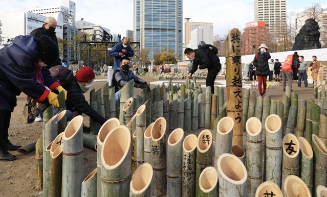 灯籠で「むすぶ」の文字を形作り、準備作業をする人たち＝１６日午後、神戸市中央区加納町６