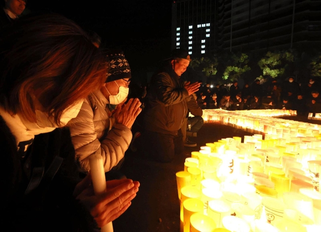 黙とうをささげる人たち＝１７日午前５時４６分、神戸市中央区、東遊園地