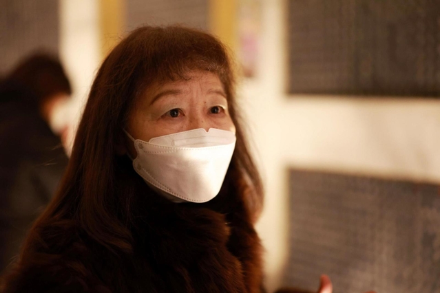 亡くした母を思い、瞑想空間を訪れた寺内和子さん＝１７日午前５時２７分、神戸市中央区加納町６、東遊園地