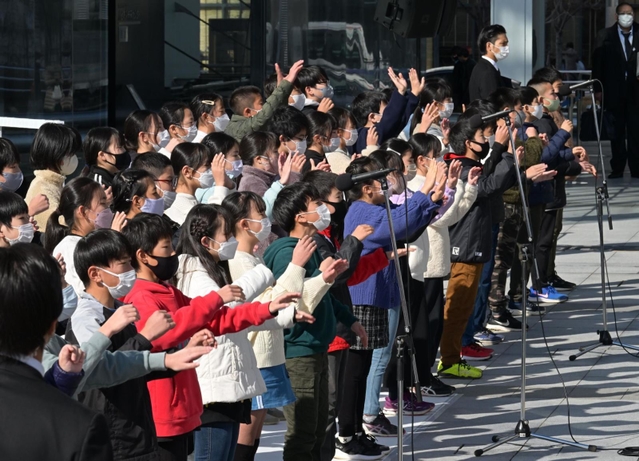 「しあわせ運べるように」を合唱する灘の浜小学校の児童たち＝１７日午後０時２９分、神戸市中央区脇浜海岸通１
