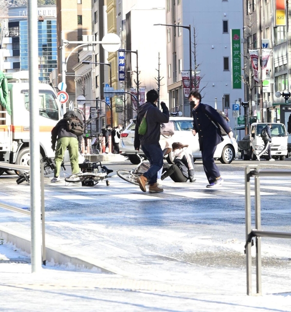 凍り付いた道路で転ぶ人々＝２５午前８時５０分、神戸市中央区