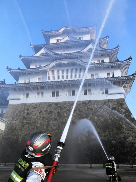 姫路城大天守に向かって放水する消防隊員ら＝２６日午前、姫路市本町