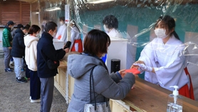 縁起物を手渡す長田神社の巫女＝１日午前、神戸市長田区長田町３、長田神社