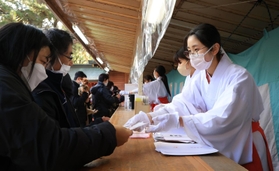 縁起物を手渡す長田神社の巫女＝１日午前、神戸市長田区長田町３、長田神社