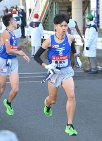 梶谷優斗（左）からたすきを受け取り、走り出す東海大・石原翔太郎＝鶴見中継所