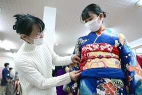 母親の吉村幸子さん（左）が愛用した振り袖を着付けてもらう娘の若菜さん＝尼崎市武庫之荘２、きもの利休尼崎本店