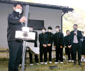 夢が丘中学校に設置されたシカよけの超音波スピーカー。斎藤元彦知事（左端）も視察に訪れた＝昨年１１月下旬、兵庫県新温泉町細田