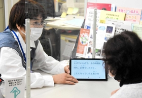 文字起こしアプリを使った実験で、窓口の市民に対応する三木市職員（左）＝昨年１２月、三木市役所