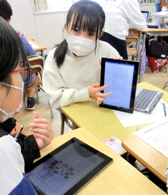 パソコンの画面を見せ合い、震災について調べたことを発表する５年生＝西灘小学校