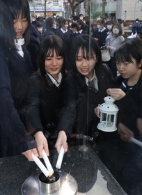 「１．１７希望の灯り」から火を移す参加者ら＝８日午後、神戸市中央区加納町６
