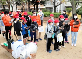大学生と一緒に、公園の防災倉庫を見学する西灘小の５年生ら＝神戸市灘区都通３