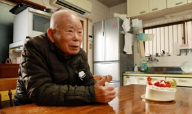 「６３」と飾られた有本恵子さんの誕生日ケーキと父明弘さん＝１２日午後、神戸市長田区