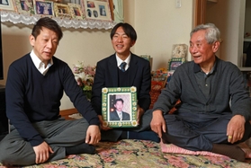 秀光さんの遺影を手に、夢を語る崔雄貴さん。父秀英さん（左）、祖父敏夫さんが笑顔を見せる＝神戸市須磨区千歳町１