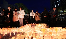 阪神・淡路大震災の犠牲者に祈りを捧げる人たち＝１６日午後５時４７分、神戸市中央区加納町６、東遊園地