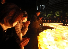 黙とうをささげる人たち＝１７日午前５時４６分、神戸市中央区、東遊園地