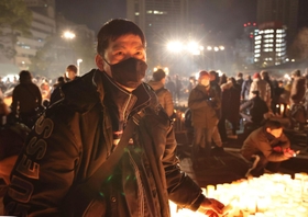 亡くなった父親への思いを語る板倉哲也さん＝１７日午前５時３３分、神戸市中央区加納町６、東遊園地