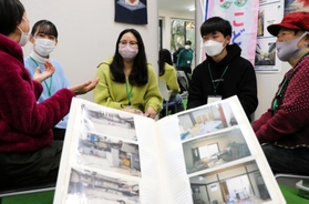 阪神・淡路大震災の話を含め、和やかに語り合う高校生、大学生と住民ら。手前は震災直後の写真＝神戸市灘区中郷町５、地域共生拠点・あすパーク