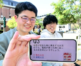 開発した防災ゲーム「バージ」の画面を見せる若者防災協議会代表の稲澤遥樹さん（左）と、代表補佐の野田宗汰さん＝神戸市中央区、神戸学院大学