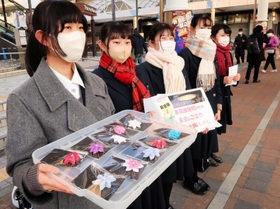 花飾りを用意し、募金への協力を呼びかける神戸常盤女子高校の生徒＝１７日午後４時３２分、神戸市長田区若松町