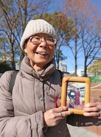 震災で亡くなった母の写真を手に、東遊園地を訪れた中本利子さん。母の笑顔を心に思い浮かべる＝１７日午前１０時２２分