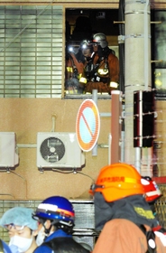 現場を調べる消防隊員ら＝２２日午前２時５１分、神戸市兵庫区湊町１