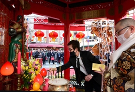 僧侶の読経に合わせ、関羽像の前に線香を供える来賓客＝２２日午前、神戸市中央区元町通１、南京町広場