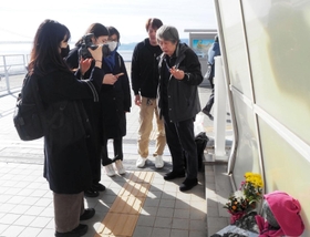 歩道橋事故の遺族、下村誠治さん（右端）と事故現場を取材する「時事ＩＮ」の記者たち＝１月３日、明石市大蔵海岸通１