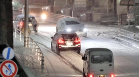 急な積雪で路面が真っ白になった上り坂。スリップする車両が相次ぎ、後ろから車を押す人もいた＝２４日午後８時３３分、神戸市垂水区星陵台